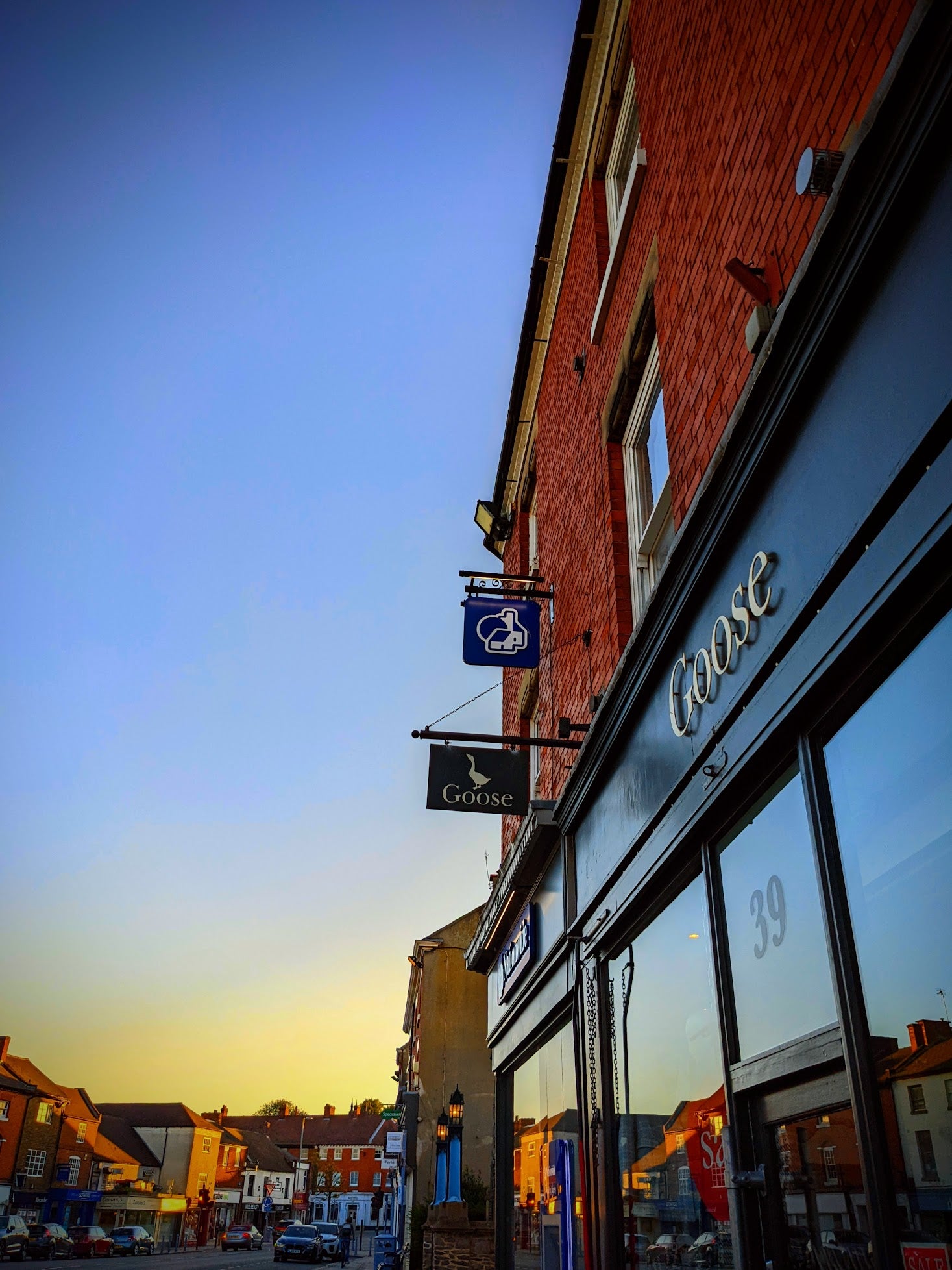Image of Goose Womens Clothing store in Ashby De La Zouch from the outside with the sun setting in the background